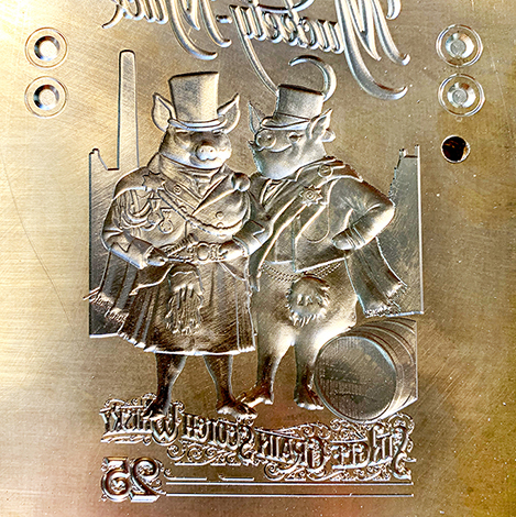 Sculpted multi-level brass emboss die of two gentlemen pigs and type for a wine label