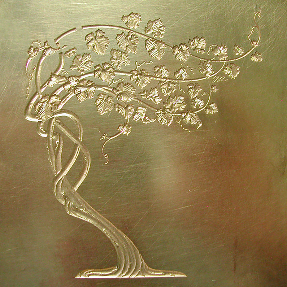 Sculpted multi-level brass emboss die of stylized grapevines for a wine label